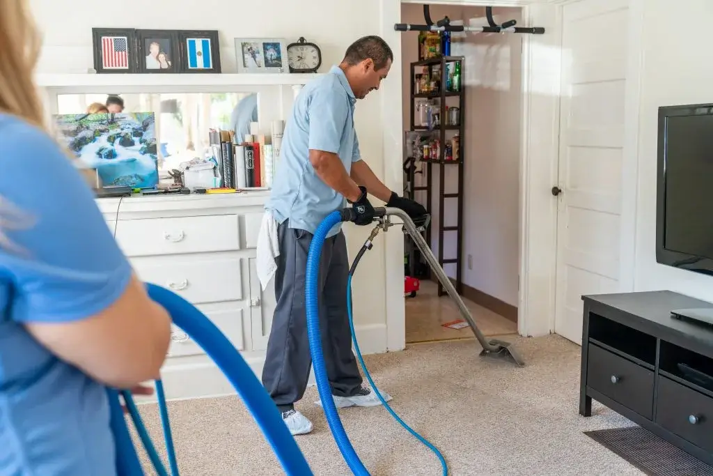 Carpet cleaning pros using vacuum 