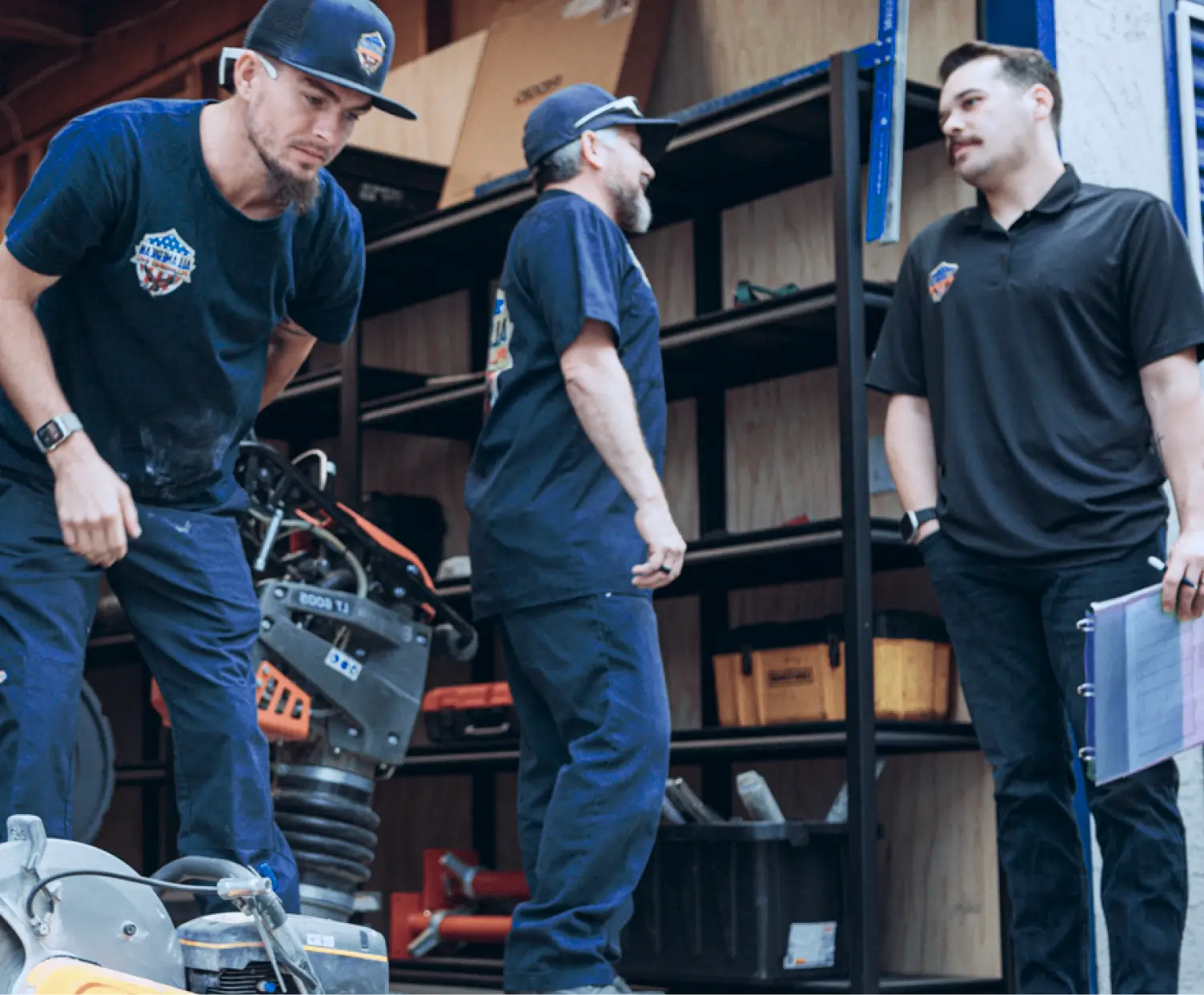 All American Plumbing team members in workshop setting with tools and equipment, representing loyal customers of using Housecall Pro’s software for 7 years.