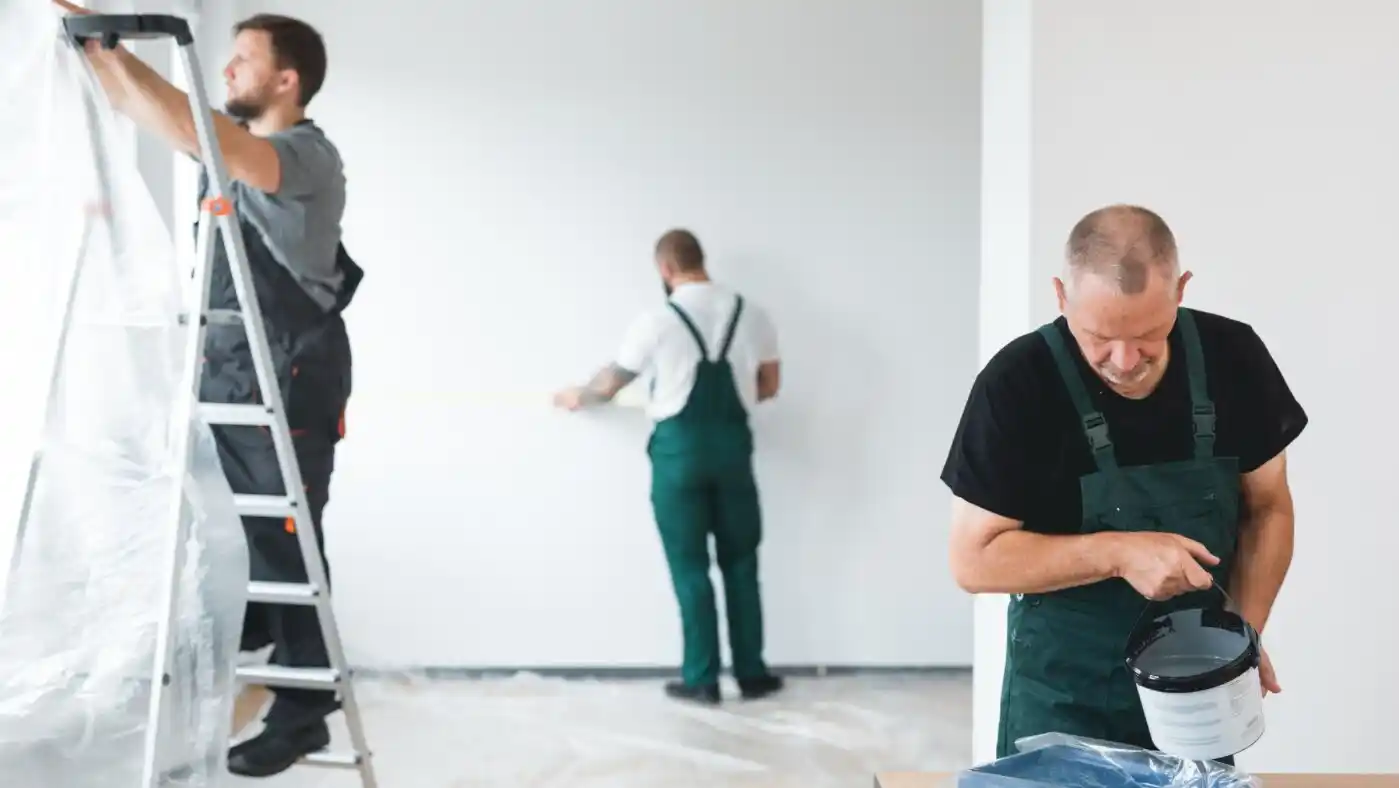 professional renovation crew painting walls of newly built apartment